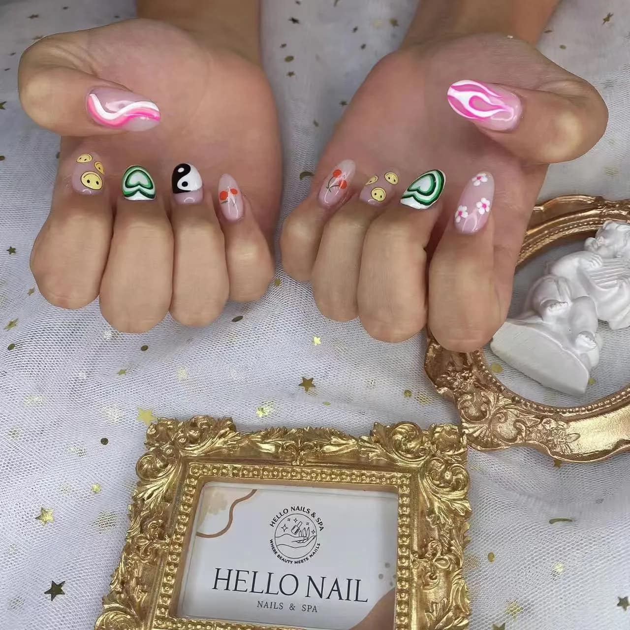 Short nails with smiley faces, yin-yang and pink swirl art