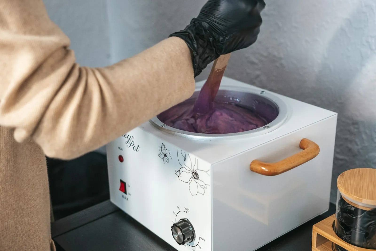 Technician preparing warm wax for a waxing service